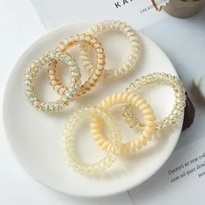 Detailed view of assorted colorful spiral telephone wire hair ties on a white plate