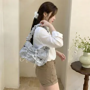 Stylish Korean style pleated plaid shoulder bag with delicate bow details worn by model