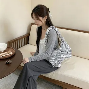 Detail view of a Korean style pleated shoulder bag featuring blue white stripes and bows