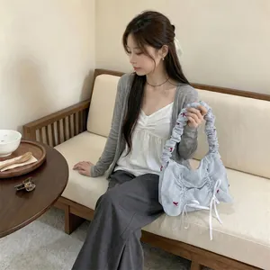 Korean style blue and white striped ruched handbag with bow detail shown in lifestyle setting