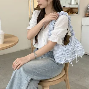 Lifestyle shot of a Korean pleated blue and white striped shoulder bag with bows
