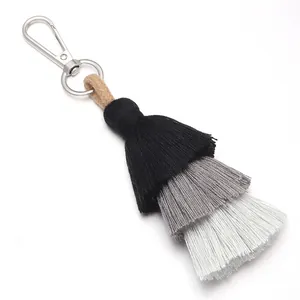 Detail view of three-layer cotton tassel pendant with silver metal lobster clasp