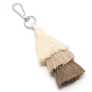 Close-up detail of a three-layered gradient cotton tassel bag charm with a metal clasp