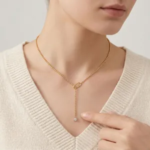 Minimalist gold bead chain Y-necklace with geometric link and round crystal drop.