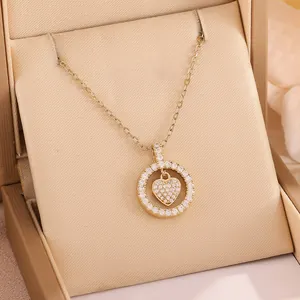 Elegant gold-tone heart necklace with sparkling circular ring pendant in gift box.