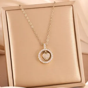Elegant minimalist gold circle and heart pendant necklace with cubic zirconia.