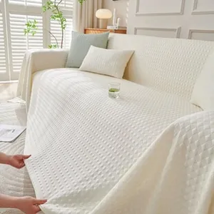 Close-up detail of a white quilted chenille sofa cover showing texture and full coverage.