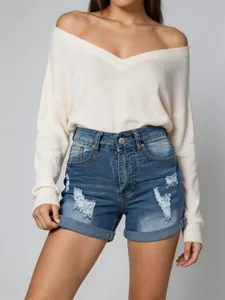Détail de short en jean déchiré pour femme avec ourlet revers et taille haute