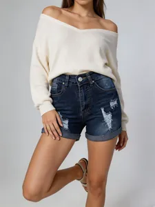 Vue rapprochée d'un short en jean bleu foncé vieilli avec revers sur mannequin