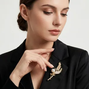 Primo piano dettagliato di un'elegante spilla a forma di grano con perle su blazer nero.