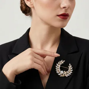 Elegante spilla a corona d'alloro dorata con cristalli su blazer nero abito da sera