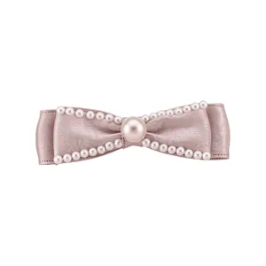 Elegant pink satin bow hair clip decorated with white pearls on a clean white background