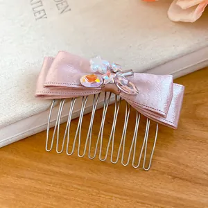 Close-up detail of an elegant pink satin bow hair comb with sparkling crystal rhinestones