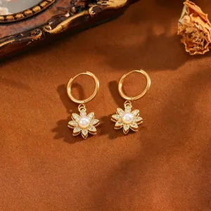 Elegante goudkleurige vintage oorringen met centrale parel en kristallen bloemblaadjes detail