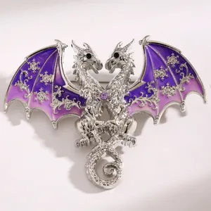 Detailed macro view of a silver double-headed dragon brooch with purple enamel wings.