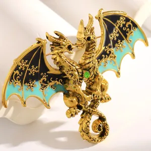 Macro detail of fantasy double-headed dragon brooch with blue enamel and green gem