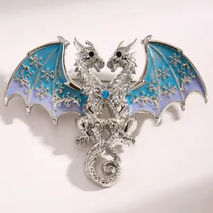 Detailed macro view of fantasy double-headed dragon brooch with blue enamel wings