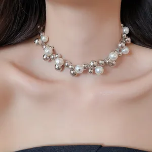Dettaglio ravvicinato di una collana di tendenza con perle bianche e sfere d'argento sulla modella