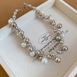 Dettaglio ravvicinato della collana multistrato con perle d'argento e perle bianche