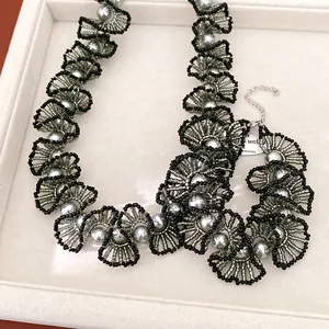 Détail d'un collier en dentelle de perles de verre fait main avec perles grises élégantes