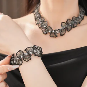 Détail d'un élégant ensemble collier et bracelet en dentelle de perles noires et perles grises