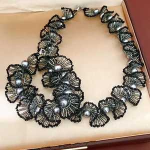 Collier de dentelle en perles de verre fait main exposé dans un écrin de bijoux de luxe