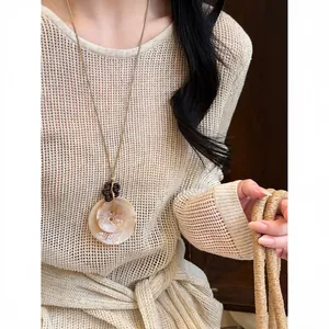Bohemian Maillard style long necklace featuring irregular resin pendants and floral detail