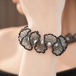 Détail d'un collier en dentelle de perles de verre fait main avec des perles argentées