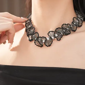 Détail du collier ras de cou élégant en perles de verre noires et perles grises.