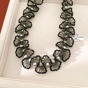 Gros plan détaillé d'un élégant collier en dentelle de perles et de perles de verre