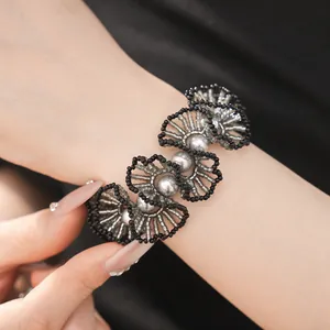 Gros plan d'un bracelet en dentelle de perles noires et argentées fait main