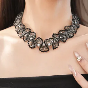 Vue rapprochée d'un collier de perles en dentelle fait main noir et gris sur un modèle
