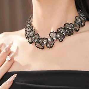 Détail d'un collier vintage en perles de verre avec perles grises et accents noirs.