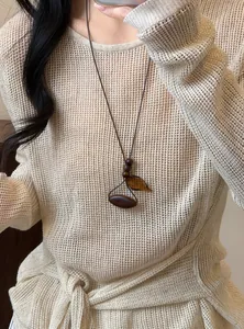 Detailed view of an irregular wooden pendant necklace in stylish Maillard tones for women.