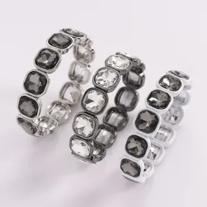 Close-up of three square crystal elasticated bracelets in grey, clear, and smoke colors