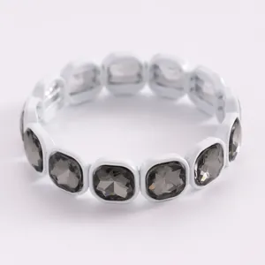 Close-up of elegant white frame bracelet with smoky grey faceted acrylic crystals
