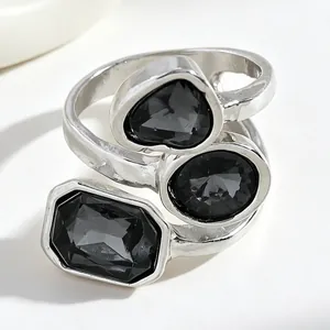 Detailed close-up view of irregular black acrylic gemstones set on a silver-toned ring