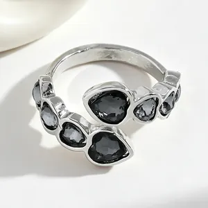Close-up of a silver-colored ring featuring multiple black heart-shaped stones
