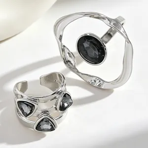 Detailed close-up of minimalist irregular silver rings with black acrylic stones