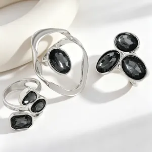 Detail shot of three irregular silver rings featuring faceted black stones in a set.