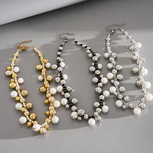 Primo piano di collane con perle e perline metalliche in oro e argento