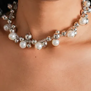 Primo piano di una collana vintage di perle e sfere d'argento dal design elegante.