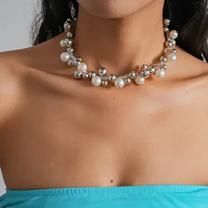 Primo piano di un'elegante collana girocollo con perle e sfere d'argento su una modella