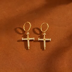 Detailaufnahme eleganter goldfarbener Kreuznagel-Creolen mit funkelndem Zirkonia-Besatz