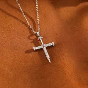 Detailansicht einer silbernen Kreuzhalskette im Nagel-Stil mit schimmernden Zirkoniasteinen.