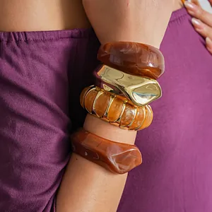 Detailopname van onregelmatige geometrische acrylhars armbanden met amber marmertextuur