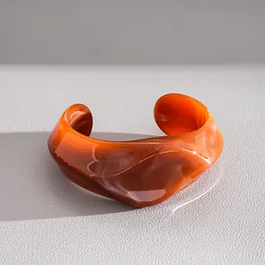 Macro-opname van een oranje gemarmerde onregelmatige geometrische acryl armband