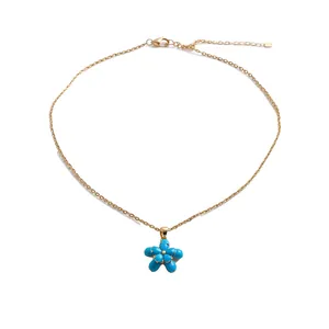 Collana placcata oro 18 carati con ciondolo a fiore di zircone blu su sfondo bianco