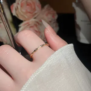 Dettaglio di un delicato anello placcato in oro con zirconi ed effetto scintilla