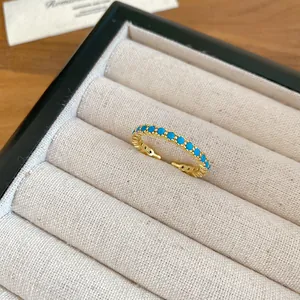 Primo piano di un anello placcato oro 18k con pietre di zircone turchese in un portagioie